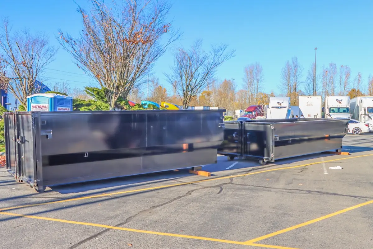 Professional dumpster rental service with roll-off container on residential driveway in Aloha